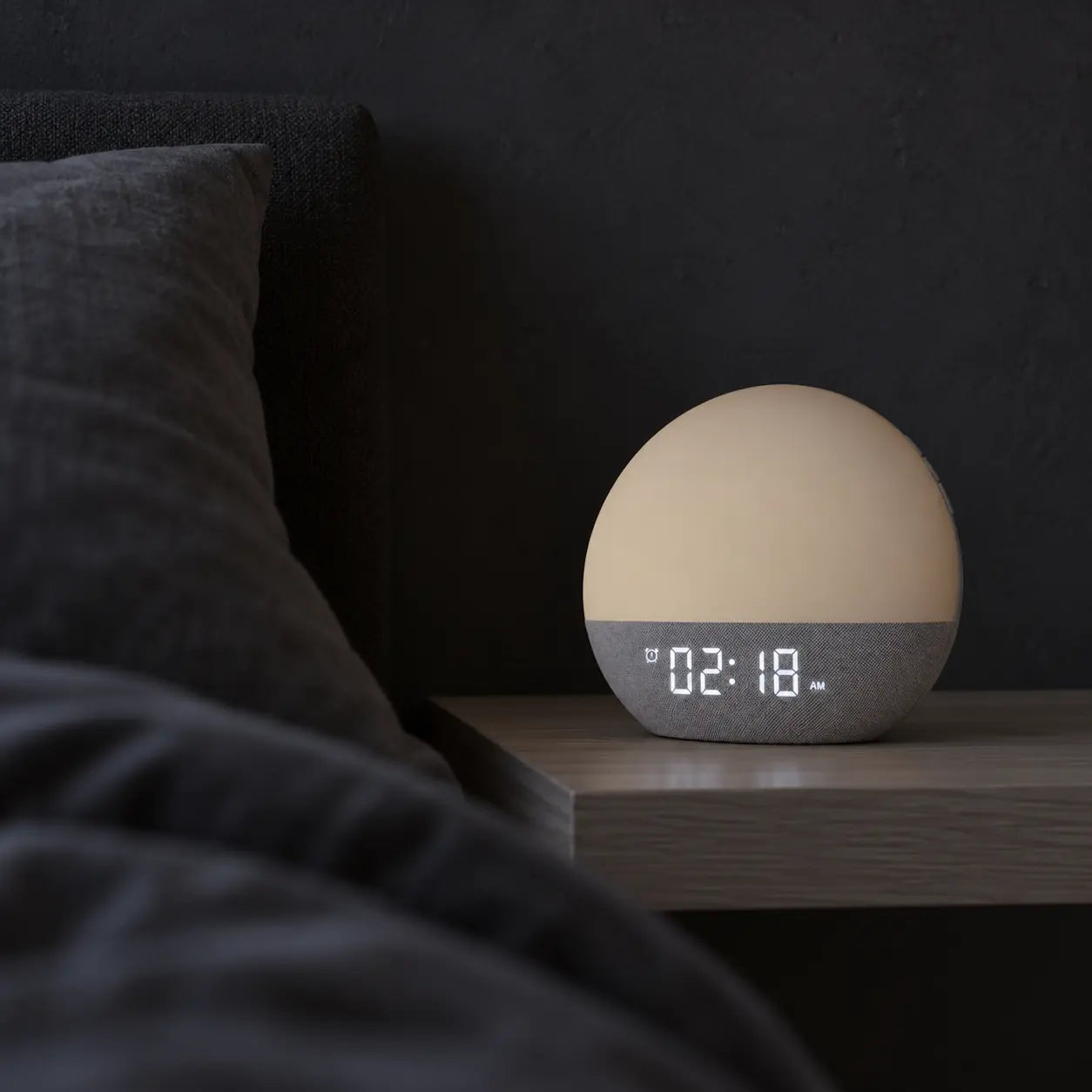 Dezente Uhrzeitanzeige im dunklen Schlafzimmer bei ausgeschalteter Lampe